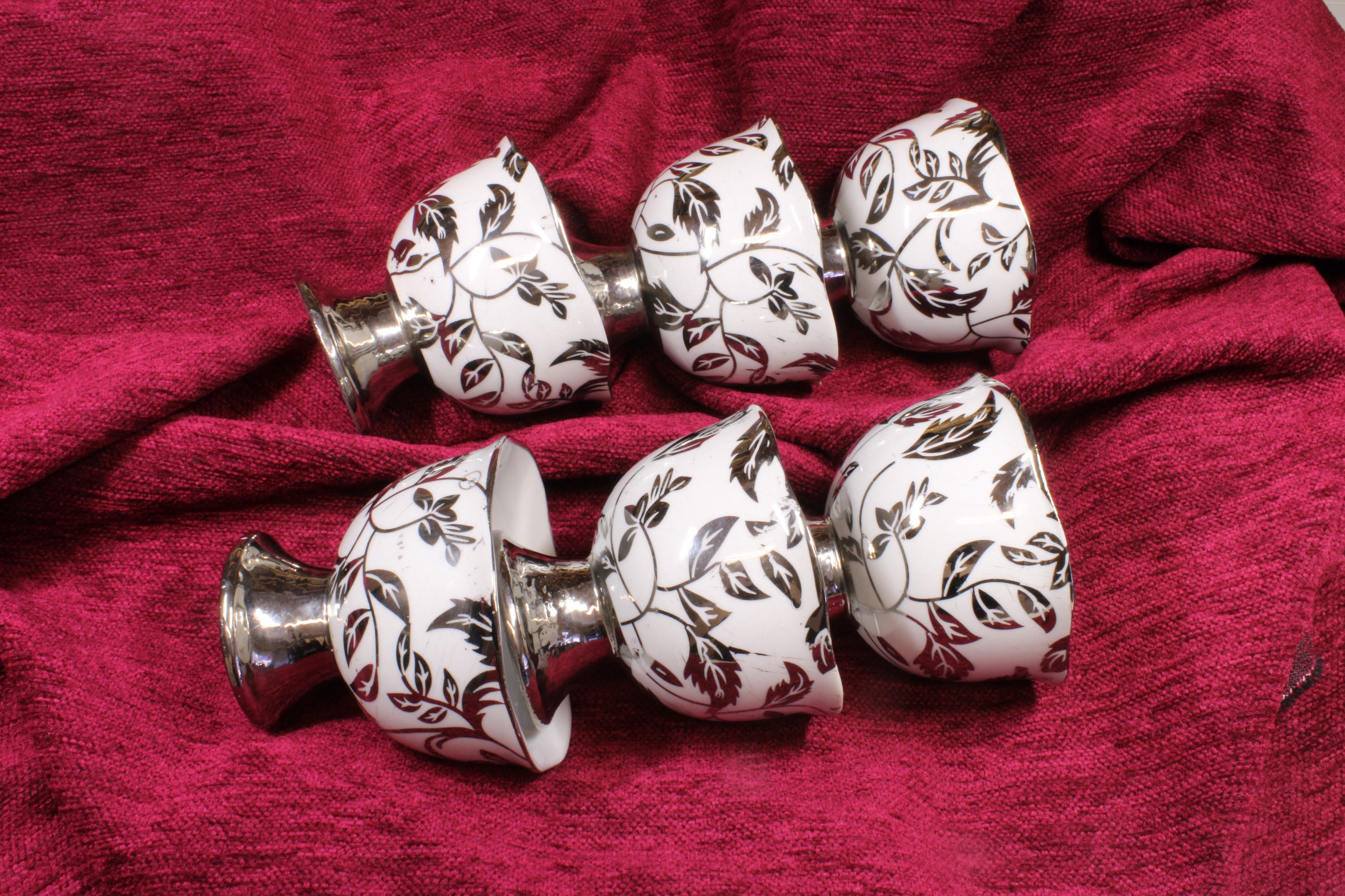 Conjunto seis copas de porcelana plateadas.