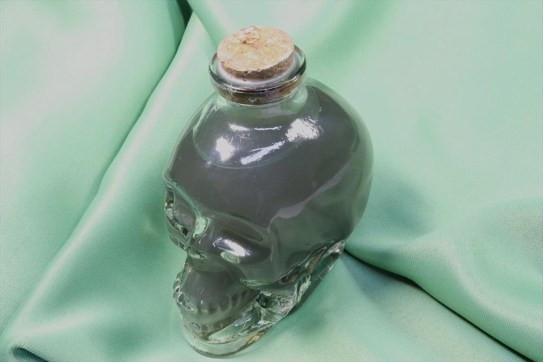 CALAVERA DE VIDRIO CON AGUA Y HIERBAS. (t)